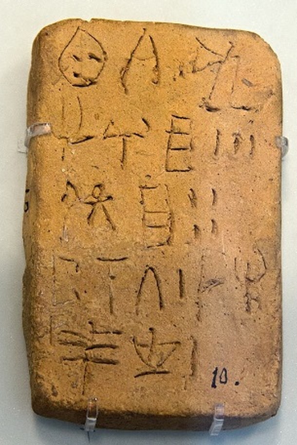 A small clay tablet with six lines of Linear A signs and short vertical strokes for units